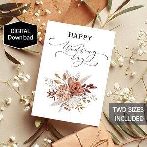 May include: A white wedding card with the words "HAPPY Wedding day" in elegant script, adorned with a floral arrangement in shades of brown, peach, and white. The card is surrounded by decorative elements and the text "TWO SIZES INCLUDED".