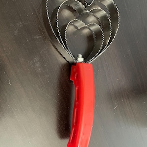 May include: A heart-shaped cookie cutter set with three graduated sizes. The cutters are made of silver-colored metal with a scalloped edge. The handle is bright red and made of plastic.