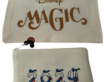 May include: Two white canvas zippered pouches. The top pouch has the text "Disney MAGIC" in gold lettering and a red Mickey Mouse head charm. The bottom pouch has the text "2024" in blue and white lettering with a red bow on each number and a Mickey Mouse head charm.