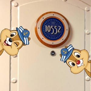 Puede incluir: Dos personajes de dibujos animados, ardillas listadas, con gorras de marinero se asoman por los lados de una puerta crema. Una ventana redonda tipo ojo de buey muestra el número 10552 en blanco sobre un fondo azul, enmarcado por un borde de madera.