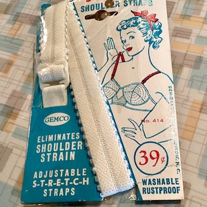 May include: Vintage package of white S-T-R-E-T-C-H shoulder straps. The package has a teal and white design with text that reads "Eliminates Shoulder Strain" and "Adjustable S-T-R-E-T-C-H Straps." The illustration shows a woman adjusting her bra strap. The price is 39¢.