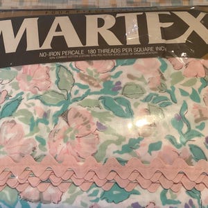 May include: A four-piece Martex sheet set in a plastic package. The sheets have a floral design with pink, teal, and purple flowers on a white background. The package reads "NO-IRON PERCALE 180 THREADS PER SQUARE INCH". A pink scalloped trim is visible.