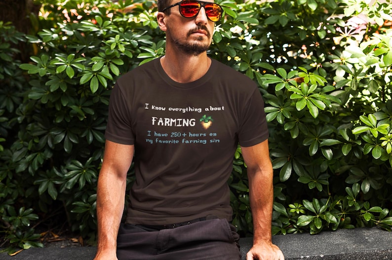 Funny brown t-shirt with the text "I know everything about farming – I have 250+ hours on my favorite farming sim" and a pixel art parsnip. Retro-inspired, humorous, and perfect for indie game lovers who spend hours managing crops and building peaceful digital lives.