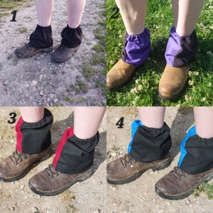 May include: Four pairs of black gaiters with different coloured accents. The gaiters are worn over hiking boots. The accents are red, blue, purple, and black.