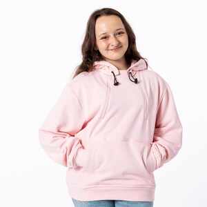 May include: A light pink hoodie with a drawstring hood and a front pocket. The hoodie is made of a soft material and has long sleeves. The model is wearing a size S.