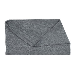 Puede incluir: Una diadema de tela gris, elástica y doblada.