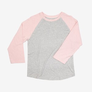 May include: A gray and pink baseball tee shirt with long sleeves. The sleeves are pink and the body of the shirt is gray.