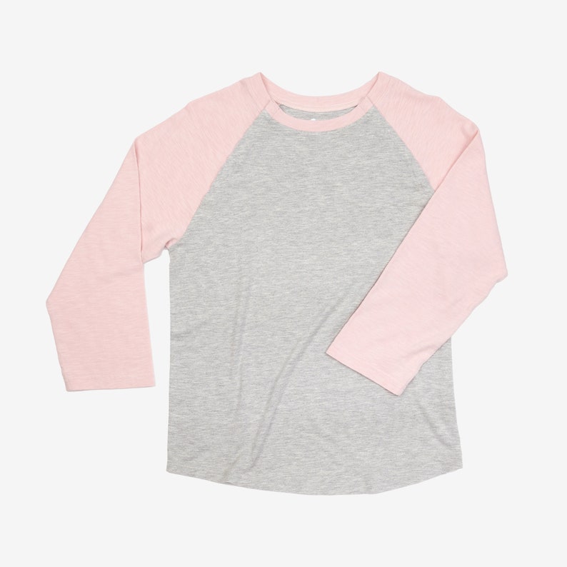 May include: A gray and pink baseball tee shirt with long sleeves. The sleeves are pink and the body of the shirt is gray.