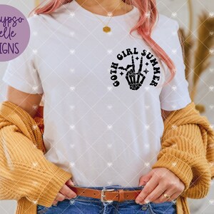 May include: A white t-shirt with a black graphic design that says "goth girl summer" with a skeleton hand making the peace sign.