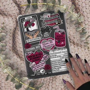 May include: A clear tablet case adorned with stickers featuring a mafia romance theme. The stickers include text like "Mafia Romance," "Under His Protection," and "Crime Lords Are My Type." The case is on a textured surface.