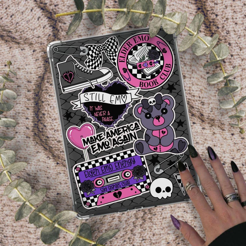 May include: A clear tablet case adorned with stickers featuring an emo theme. Stickers include a checkered bow, a high-top sneaker, a heart-shaped balloon, and a teddy bear. Text includes "STILL EMO" and "MAKE AMERICA EMO AGAIN".
