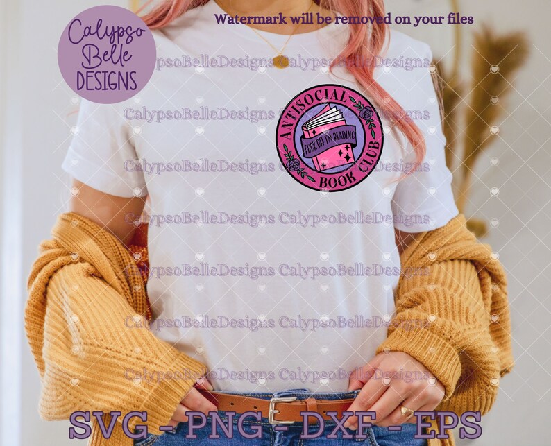 May include: A white t-shirt with a pink and purple circle design. The design features a stack of books with the text "Antisocial Book Club" and "I'd rather be reading".