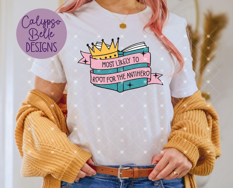 May include: White t-shirt with a pink and blue graphic of a book with a crown on top. The text on the graphic says "Most Likely to Root for the Antihero".