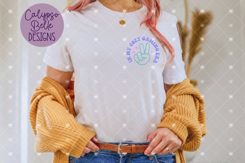 May include: White t-shirt with a graphic of a peace sign and the text "In my cozy gaming era".