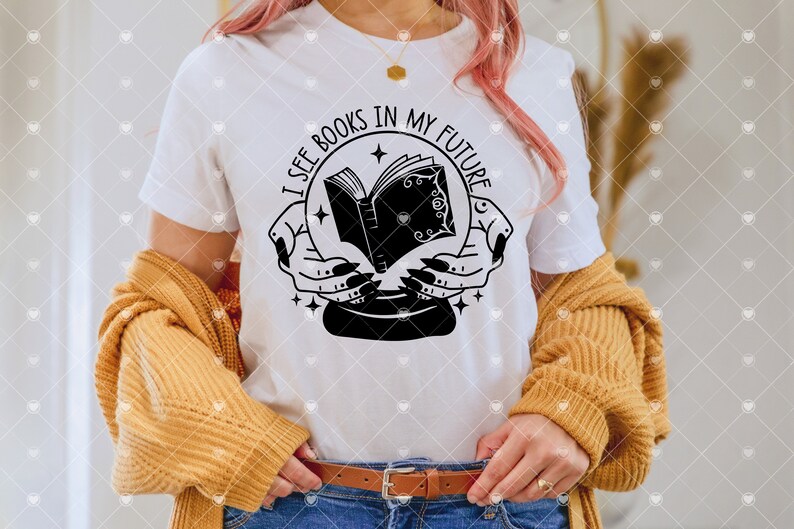 May include: White t-shirt featuring a black and white graphic of a book inside a crystal ball with the text "I see books in my future".