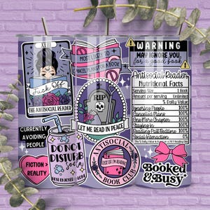 May include: A purple and white checked tumbler adorned with stickers. The stickers feature phrases such as "The Antisocial Reader," "Don't Disturb Soda," and "Booked & Busy." It includes a silver straw.