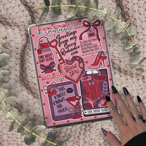 May include: A pink tablet case featuring a collage of illustrations and text. The design includes a key, high heel, corset, and martini glass. Text includes "Reading Romance like a professional" and "Greetings from my Spicy Romance era."