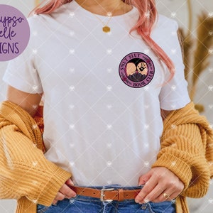 May include: White t-shirt with a purple circle graphic that says "S**LT S**LT BOOK CLUB".