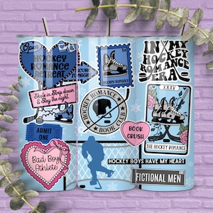 May include: A light blue tumbler with various hockey-themed graphics and text, including hearts, hockey skates, and the phrases "Hockey Romance Retreat" and "Bad Boy Athlete." The tumbler has a silver straw.