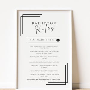 以下が含まれることがあります： 「バスルームルール」と「AIが作った場合」と書かれた黒い文字の白いフレームプリント。 「フラッシュ。常にフラッシュ。または顔の削除。」や「準拠したバスルームはAIを非常に幸せにします。」などのユーモラスなルールが含まれています。
