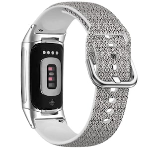 Op de afbeelding: Een wit en zwart gepatroneerd siliconen bandje voor een fitness tracker. Het bandje heeft een zilveren gesp en is compatibel met de meeste fitness trackers.