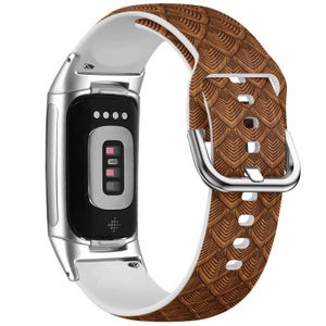Könnte beinhalten: Ein braunes und weißes Silikon-Armband mit einer silbernen Schnalle. Das Armband ist für eine Smartwatch konzipiert.