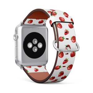 May include: A white Apple Watch band with a red strawberry pattern. The band is made of leather and has a brown leather lining.