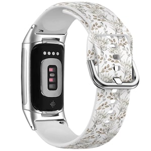 Pode incluir: Pulseira de relógio de silicone branca com padrão floral. A pulseira tem uma fivela prateada e é compatível com smartwatches.