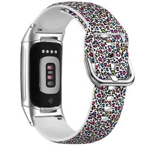 Op de afbeelding: Een witte en zilveren fitness tracker met een kleurrijk luipaardprint siliconen band. De band heeft een zilveren gesp.