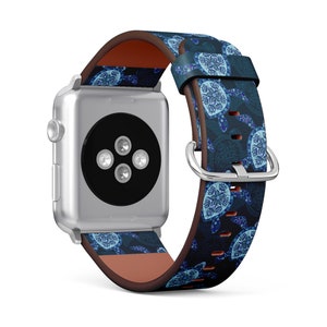 Può includere: Un Apple Watch argentato con un cinturino in pelle blu e bianco con un design a tartaruga marina. Il cinturino è foderato in pelle marrone.