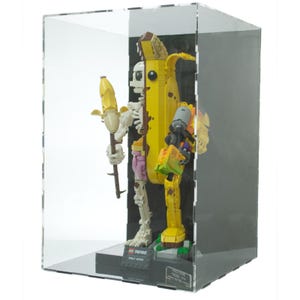 May include: A clear acrylic display case containing a Fortnite Peely Bone figure constructed from Lego bricks. The figure is a skeleton with a banana peel body, holding a staff. The base has the Fortnite logo and "Peely Bone" text.