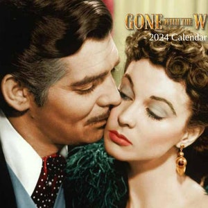 May include: A black and white photo of a couple embracing. The man is wearing a suit and tie, and the woman is wearing a white dress. The text "Gone With The Wind - 2024 Calendar -" is displayed above the couple.