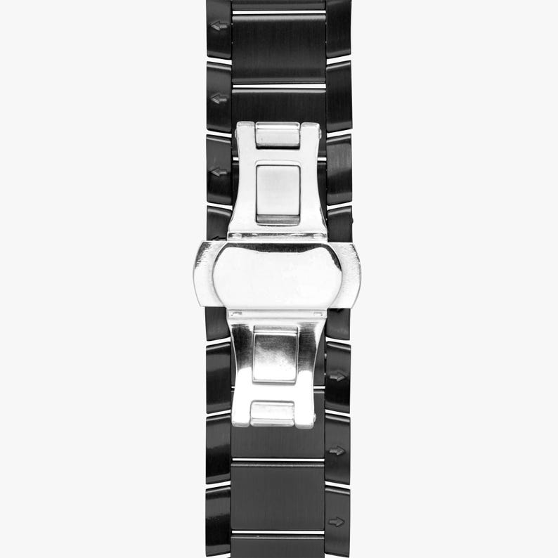 May include: Close-up of a black watch band with a silver clasp. The band is made of rectangular black links with thin white stripes. The clasp is a shiny silver color and is in the center of the band.