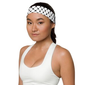May include: A woman wearing a white tank top with a black and white patterned headband.