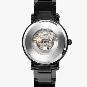 May include: Black wristwatch with a transparent back, showcasing the intricate mechanical movement. The watch has a black metal band and a round face. The watch's design emphasizes the internal gears and components, offering a glimpse into its inner workings.