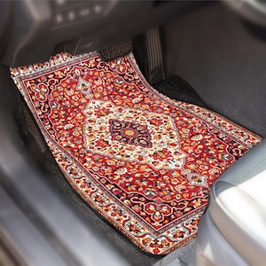 May include: A red car floor mat with an intricate Persian rug design. The mat features a central medallion and floral patterns in shades of red, orange, yellow, and blue. The mat is placed in the driver's side footwell of a car.