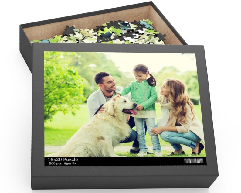 Peut inclure: Une famille de trois personnes, dont une jeune fille, un homme et une femme, profitent d'un moment de d&eacute;tente en plein air avec leur chien golden retriever. La famille sourit et interagit avec le chien dans un parc herbeux. L'image fait partie d'un puzzle de 500 pi&egrave;ces pour les enfants de 9 ans et plus.