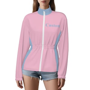 May include: A pink and light blue track jacket with the word "Custom" printed on the front. The jacket has a white zipper and a cinched waist. The sleeves are long and the collar is light blue.
