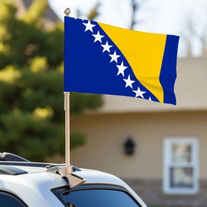 May include: A car flag featuring the flag of Bosnia and Herzegovina. The flag has a blue background with a yellow triangle and white stars. The flag is mounted on a silver car.