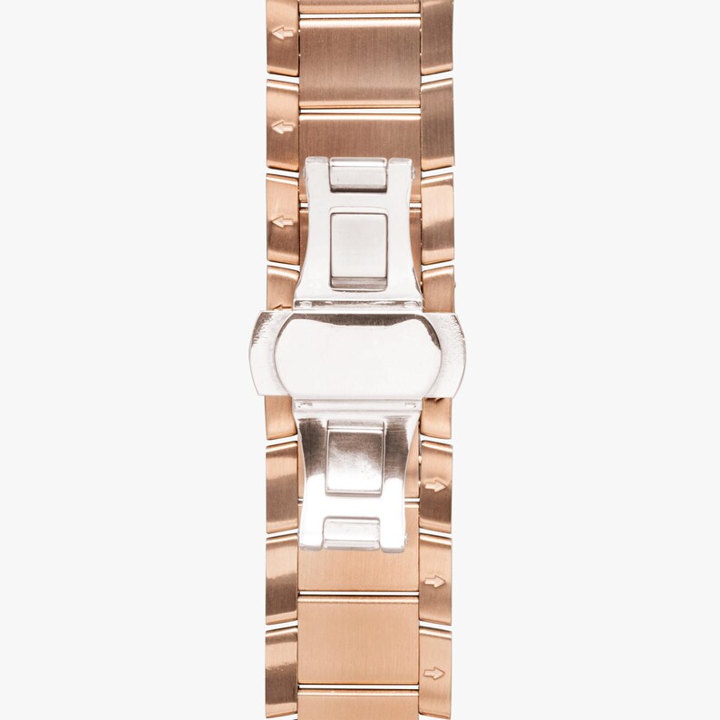 May include: Close-up of a rose gold watch band with a silver clasp. The band is made of rectangular links with a brushed finish. The clasp is a butterfly style, with a polished silver finish. The watch band is a stylish accessory.
