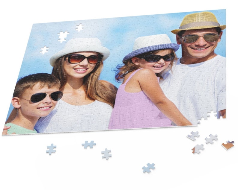 Peut inclure: Une famille de quatre personnes portant des chapeaux et des lunettes de soleil sourit pour une photo. La photo est imprim&eacute;e sur un puzzle avec quelques pi&egrave;ces manquantes.