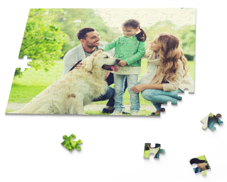 Peut inclure: Une famille avec un chien golden retriever dans un parc verdoyant. La famille est compos&eacute;e d'un homme, d'une femme et d'une jeune fille. L'homme porte une chemise bleue et un jean. La femme porte une chemise blanche et un jean. La fille porte une chemise verte et un jean. Le chien est assis sur le sol et regarde la cam&eacute;ra.