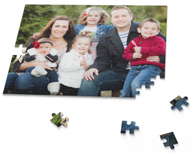 Peut inclure: Un portrait de famille montrant un groupe de cinq personnes, dont deux adultes et trois enfants. Les adultes sont assis sur un banc en plein air, tandis que les enfants sont debout devant eux. La famille sourit et regarde la cam&eacute;ra. L'arri&egrave;re-plan est une for&ecirc;t verte et feuillue.