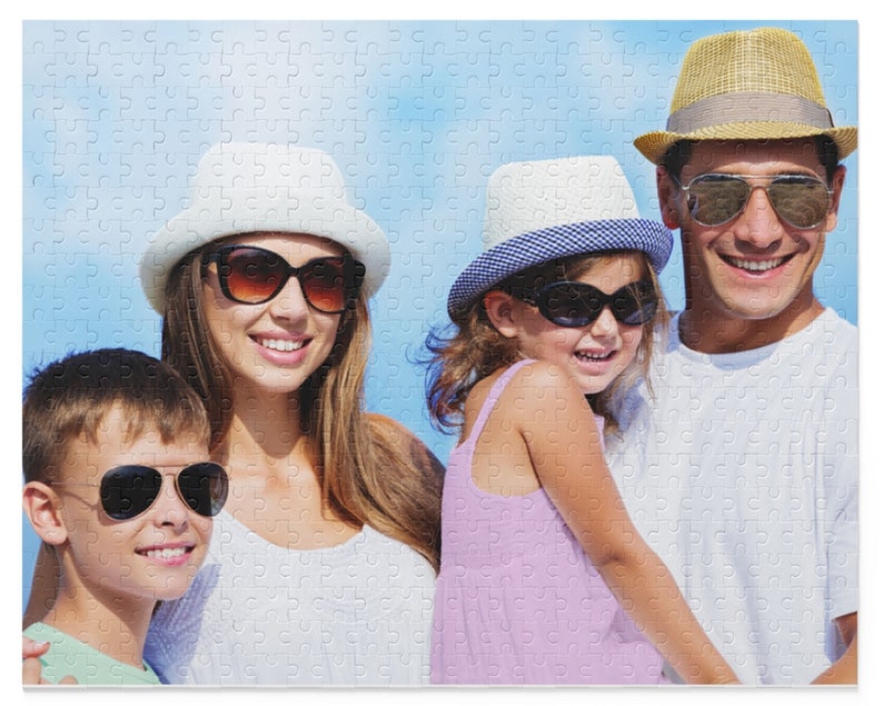 Peut inclure: Une famille de quatre personnes portant des chapeaux et des lunettes de soleil. Les parents sont debout et les enfants sont assis. L'arri&egrave;re-plan est un ciel bleu.