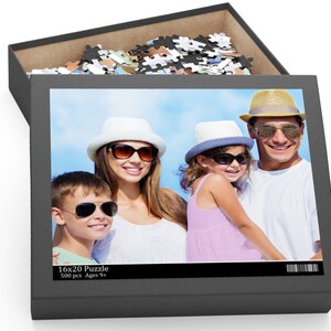 Peut inclure: Un puzzle de 500 pi&egrave;ces repr&eacute;sentant une famille de quatre personnes portant des chapeaux et des lunettes de soleil. Le puzzle mesure 40,6 x 50,8 cm et est recommand&eacute; pour les enfants de 9 ans et plus.