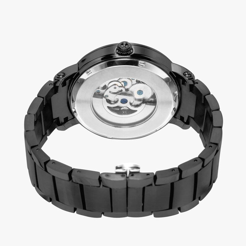 May include: Black wristwatch with a visible mechanical movement. The watch has a black metal band and a round face. The back of the watch reveals the intricate internal gears. The watch is designed with a modern aesthetic.