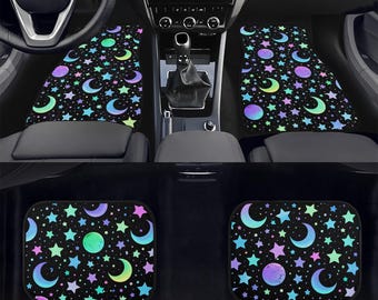 May include: Black car floor mats with a celestial pattern of stars, moons, and planets in shades of purple, blue, green, and pink. The mats are designed to fit the front and back of a car.