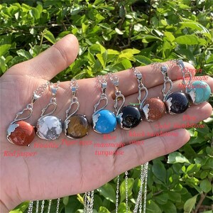 Pode incluir: Sete colares de prata com pingente de cisne com pedras preciosas de diferentes cores. As pedras s&atilde;o jaspe vermelho, howlite, olho de tigre, turquesa azul, &ocirc;nix preto, arenito vermelho e aventurina verde.