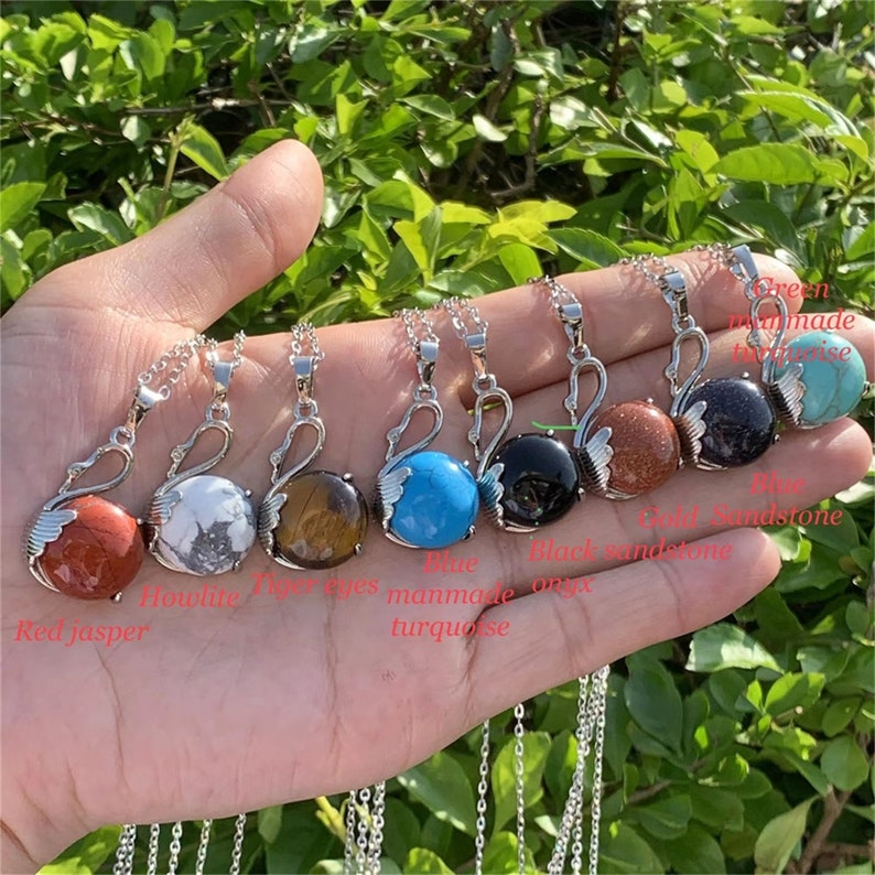 Pode incluir: Sete colares de prata com pingente de cisne com pedras preciosas de diferentes cores. As pedras s&atilde;o jaspe vermelho, howlite, olho de tigre, turquesa azul, &ocirc;nix preto, arenito vermelho e aventurina verde.