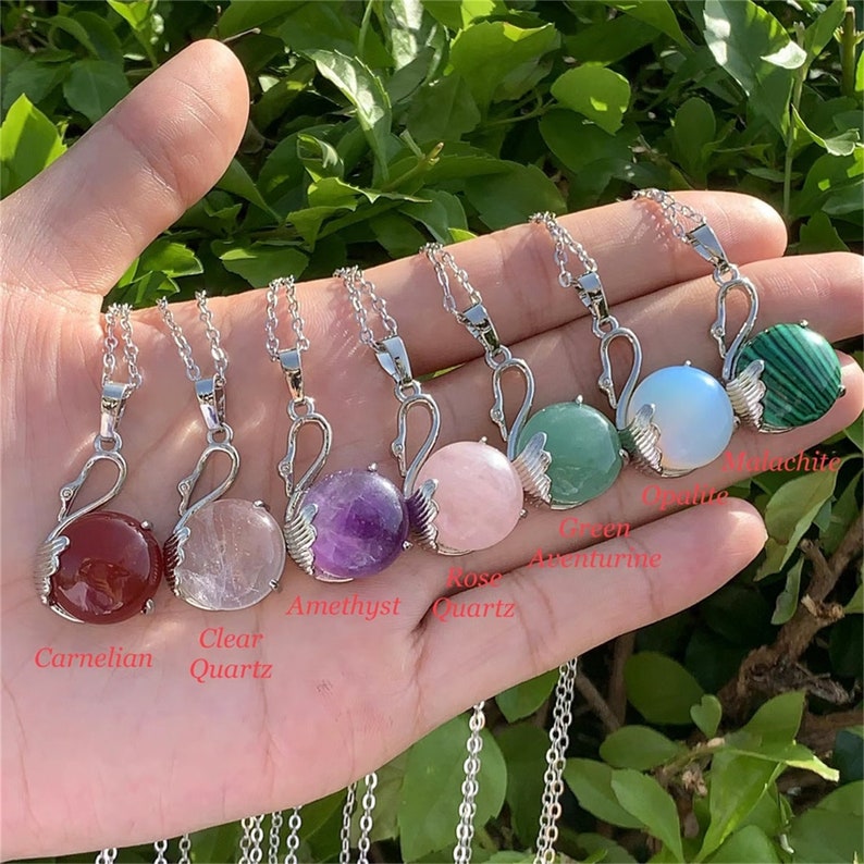 Pode incluir: Sete colares de cisne de prata com pingentes de pedras preciosas de diferentes cores. Os pingentes s&atilde;o de cornalina, quartzo transparente, ametista, quartzo rosa, aventurina verde, opala e malaquita.